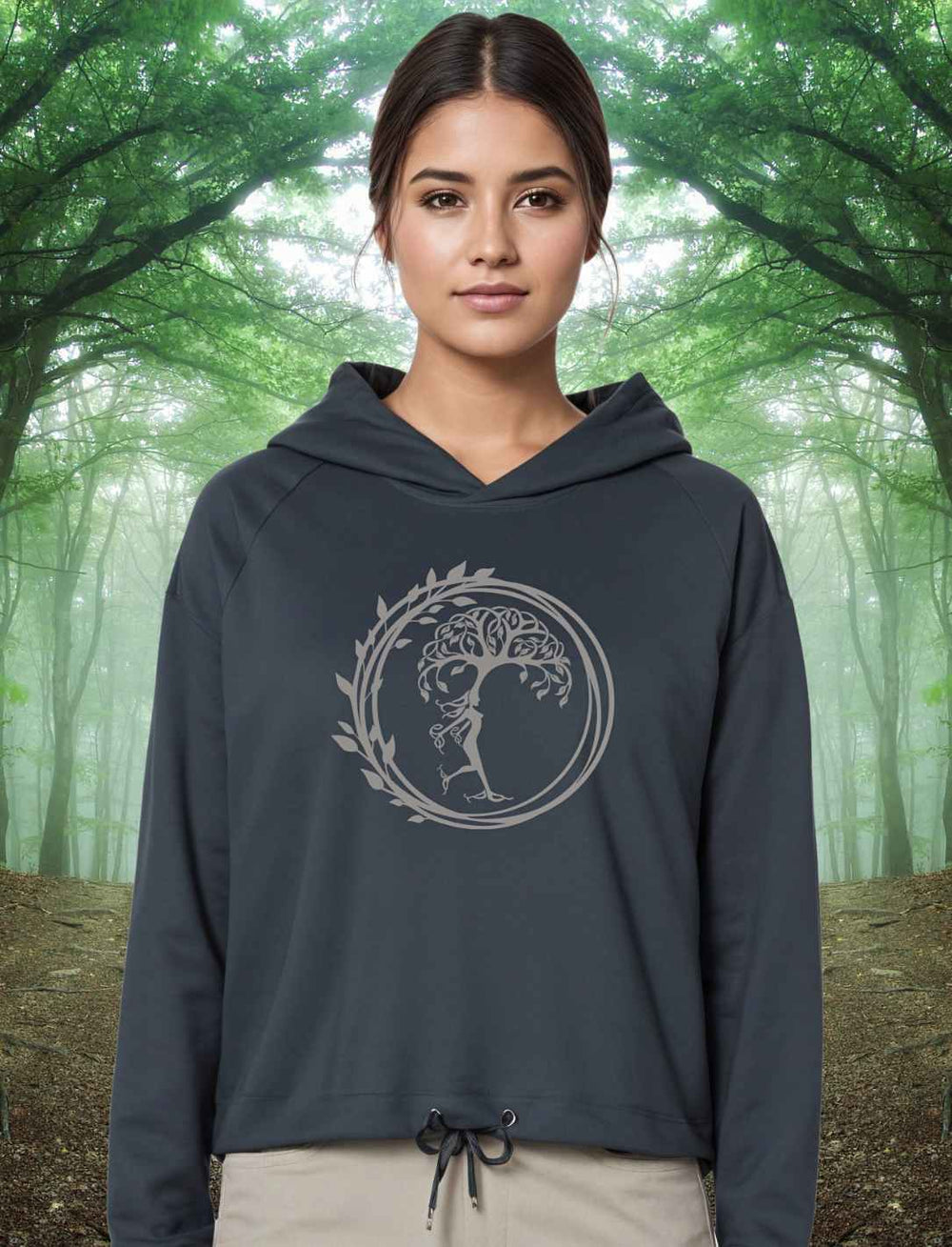 Junge Frau im Wald trägt den India Ink Grey Silvaner Lebensbaum Cropped Damen Hoodie von Runental.de, natürliche Umgebung betonend.