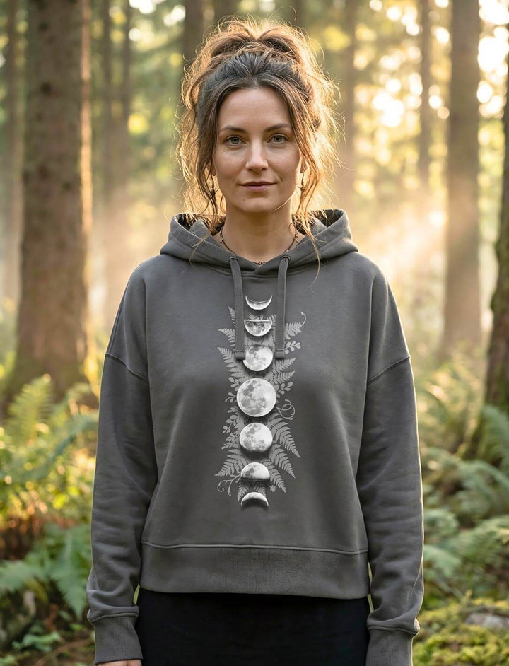 Frau trägt anthrazit Sacred Moon Boxcut Hoodie im Wald – Mondphasen Bio Hoodie Damen