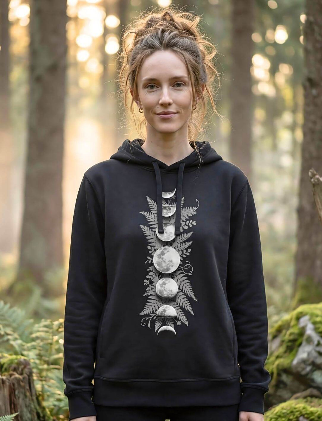 Frau trägt schwarzen Sacred Moon Hoodie im Wald – Mondphasen Organic Hoodie mit Seitentaschen