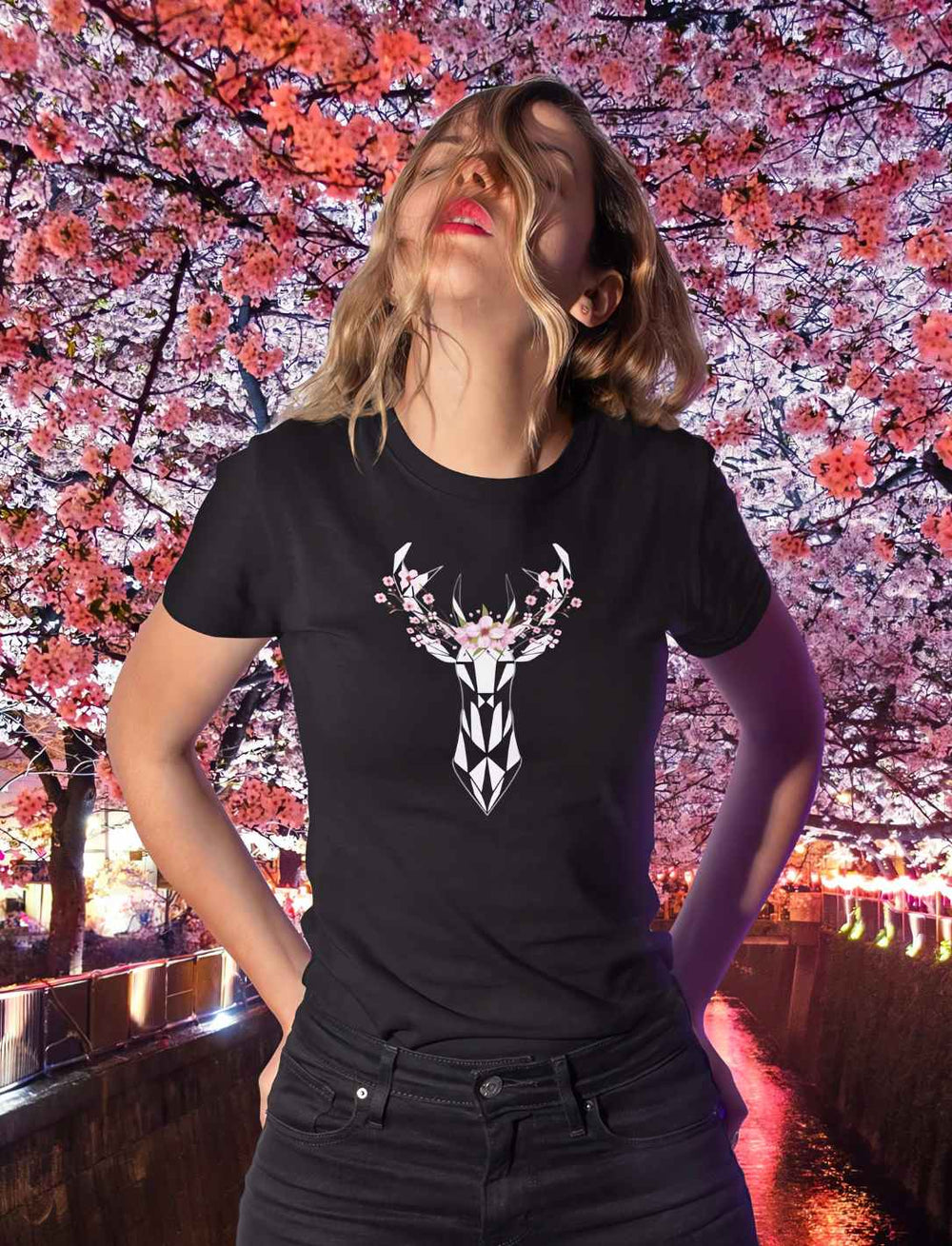 Eine junge Frau trägt das "Sakura Deer" T-Shirt in Schwarz, das Design mit Sakura-Blüten um einen stilisierten Hirsch herum, feiert die japanische Natur und Kultur.
