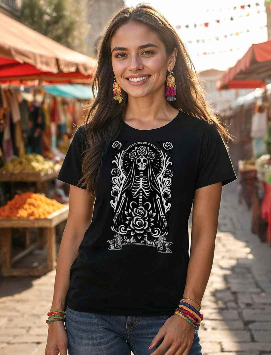 Model trägt das Santa Muerte Damen Shirt in Schwarz – inspiriert vom Día de los Muertos, fotografiert auf einem mexikanischen Markt