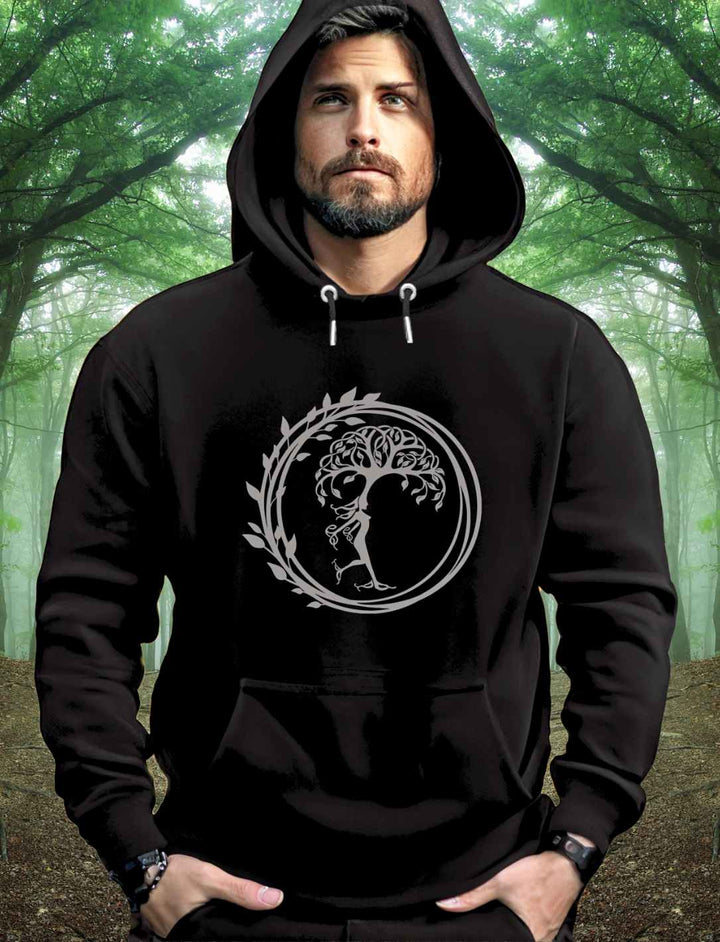 Junger Mann im Wald trägt den schwarzen Silvaner Lebensbaum Unisex Organic Hoodie von Runental.de, in natürlicher Umgebung.