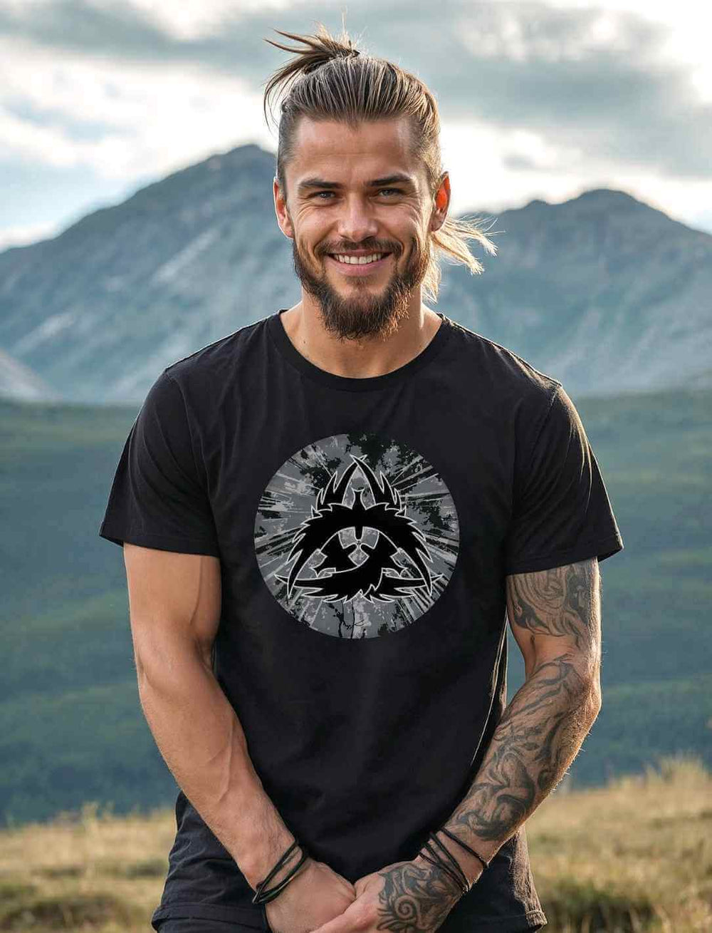 Männliches Model trägt das Unisex T-Shirt The Raven Clan in Schwarz in einer nordischen Landschaft.