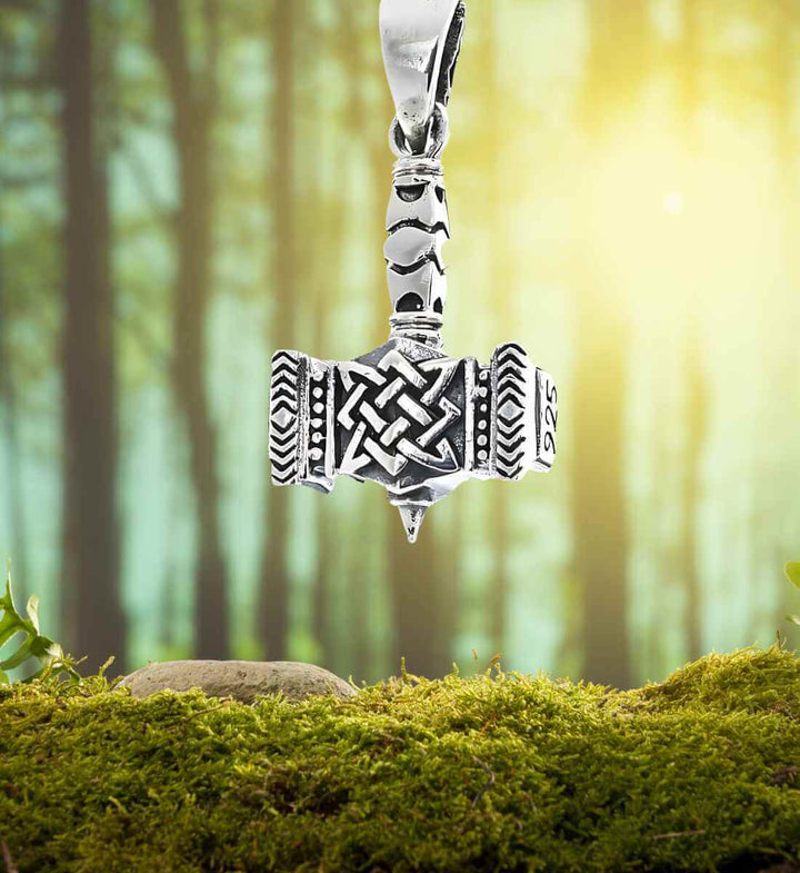 Thors Schildbrecher Anhänger auf einem Hintergrund aus Wald und Moos – Hier verschmilzt der Mjölnir Anhänger mit der Ruhe der Natur, die Thor so oft durchstreifte.