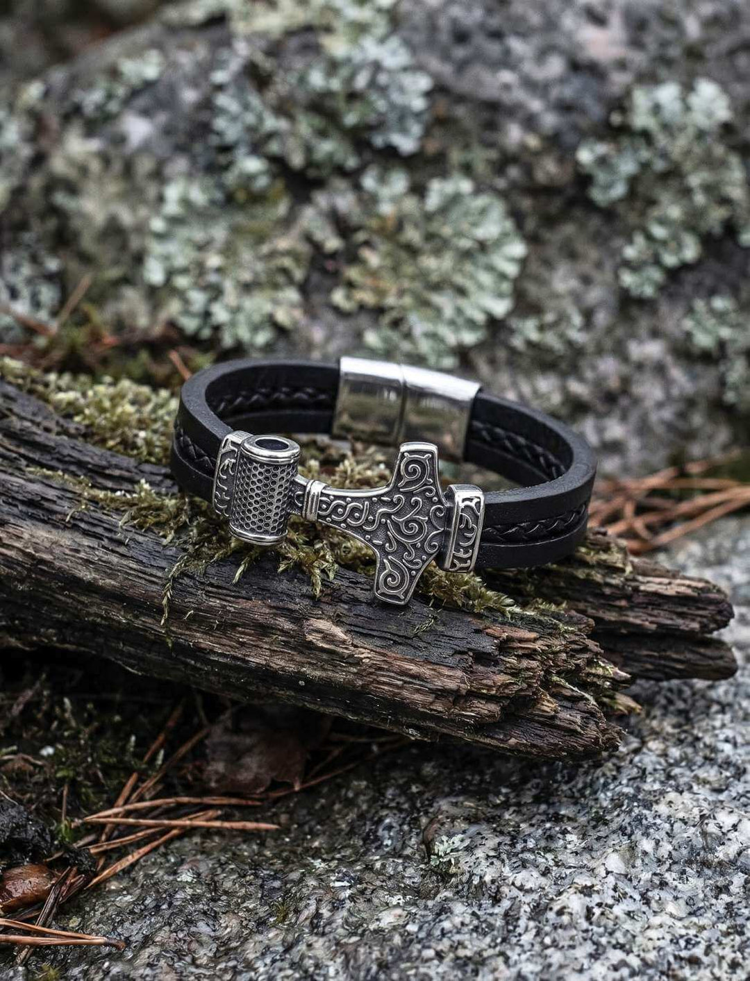 Mjölnir Lederarmband „Thor’s Schwur“ auf rauem Holz und Stein