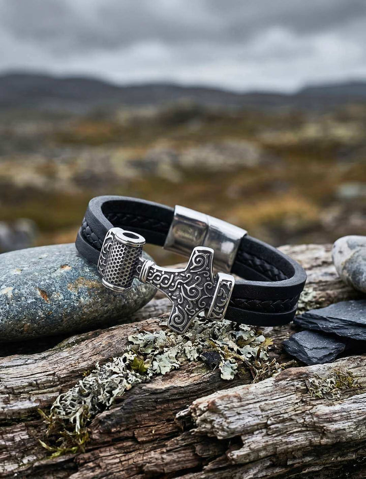 Lederarmband „Thor’s Schwur“ mit Mjölnir-Anhänger auf nordischer Landschaft