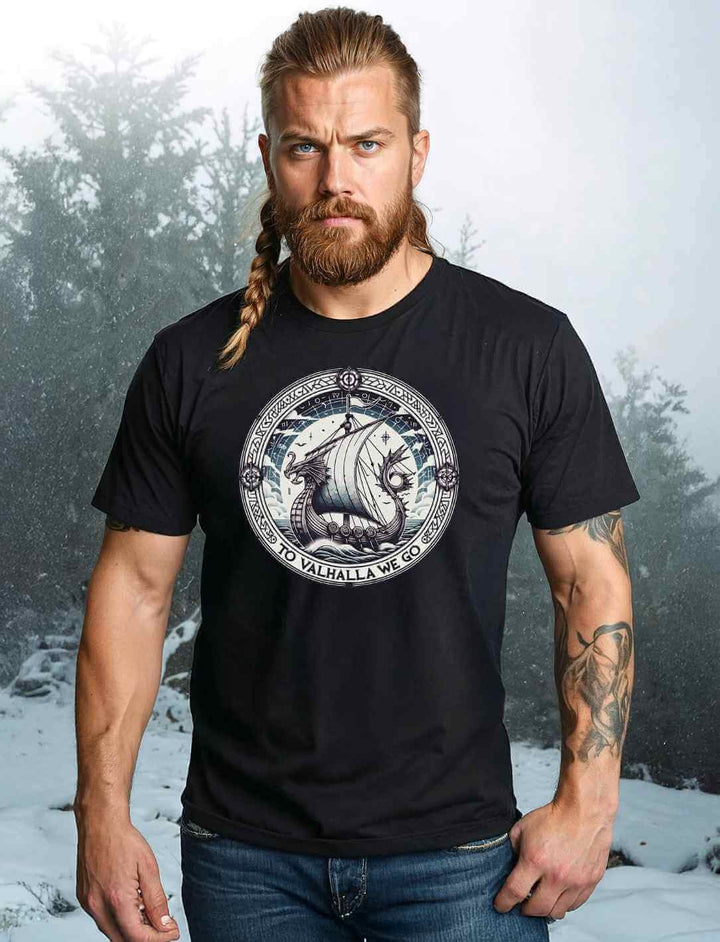 Männliches Model trägt ein Unisex Organic Shirt in Schwarz mit dem Design ‘To Valhalla We Go’ – Wikinger-Drachenboot und Runen, ein Symbol für Stärke und Ehre auf dem Weg nach Walhalla.