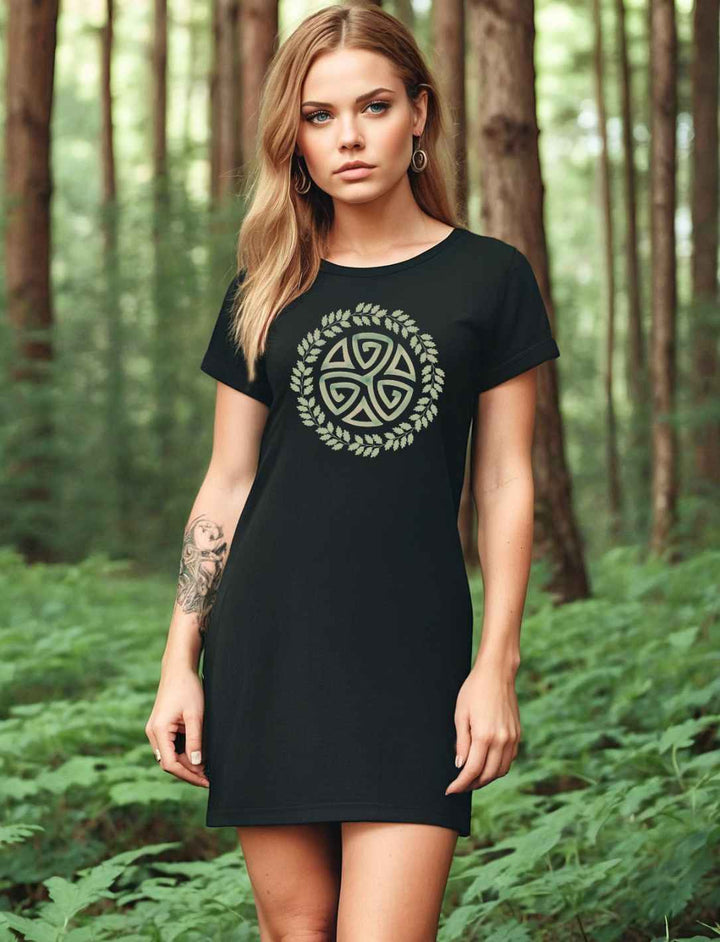 Junge Frau trägt das Triskele des Waldes T-Shirt Kleid in schwarz. Im Hintergrund ein Wald.