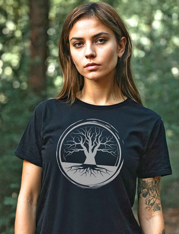 Junge Frau rägt das „Uralte Wurzeln“ Damen T-Shirt in einem natürlichen Waldumfeld, was die tiefe Verbundenheit mit der Natur unterstreicht.