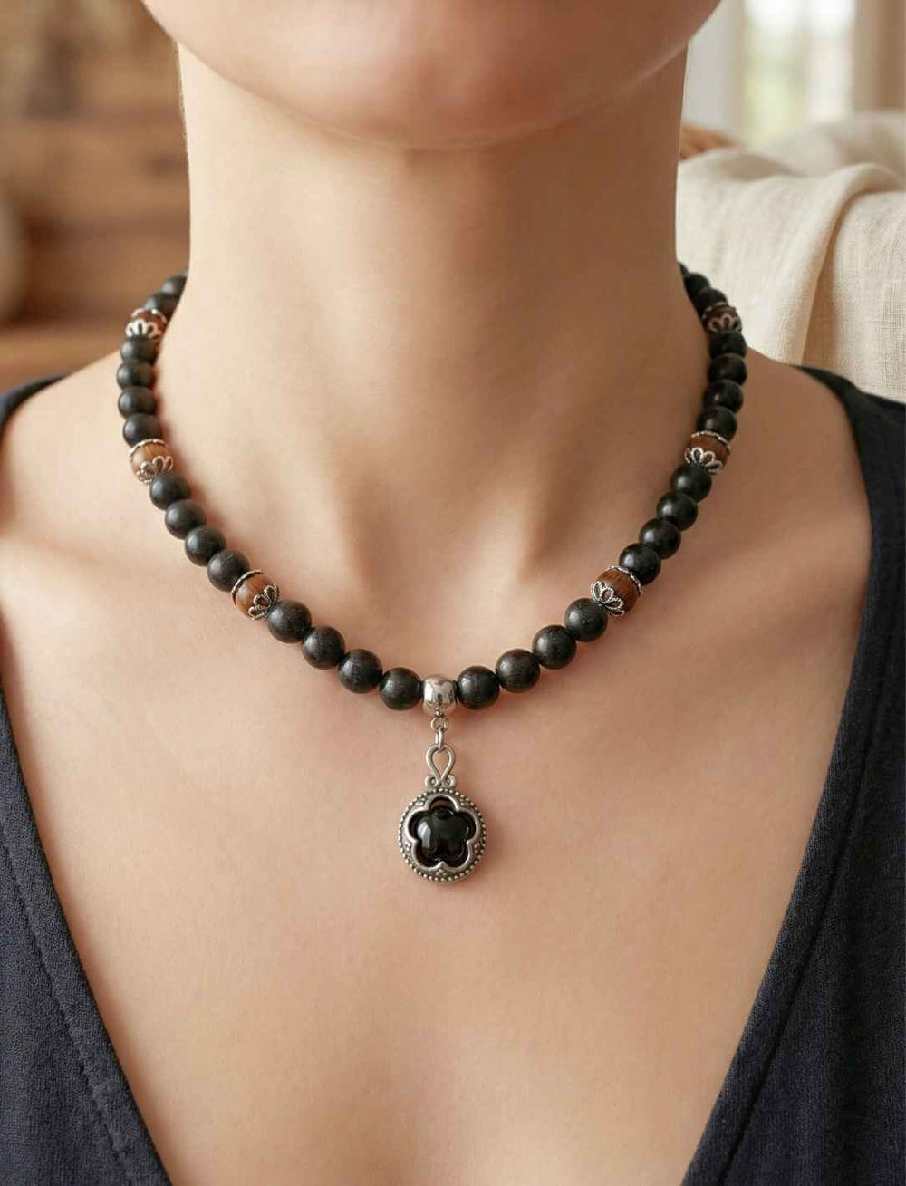 Waldhüter von Gotland – Schutzamulett mit schwarzen Holzperlen und Onyx Anhänger, getragen an einem weiblichen Model