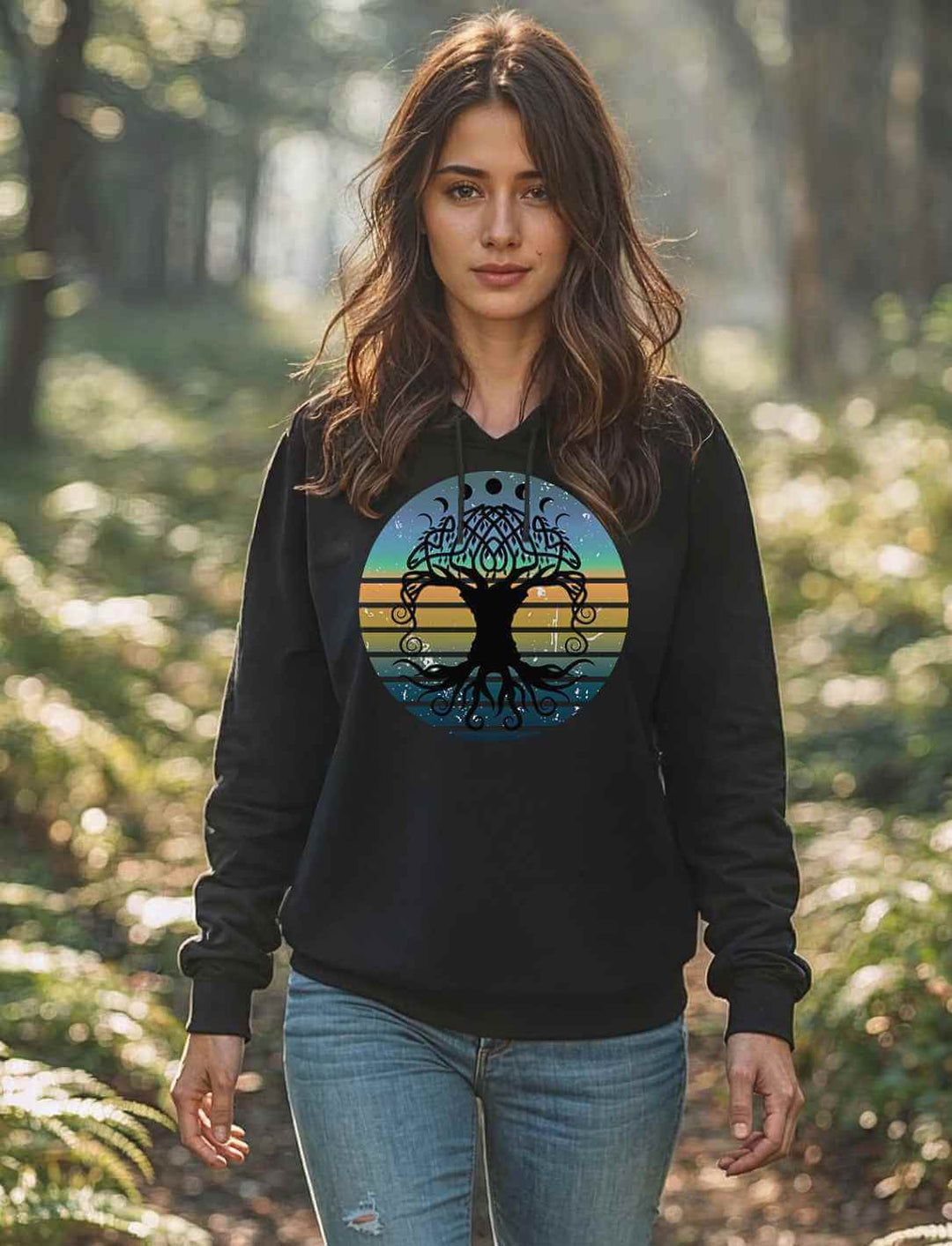 Frau im schwarzen Hoodie mit Yggdrasil-Motiv, stehend im lichtdurchfluteten Wald – gemütlicher Look für Naturverbundene | Runental