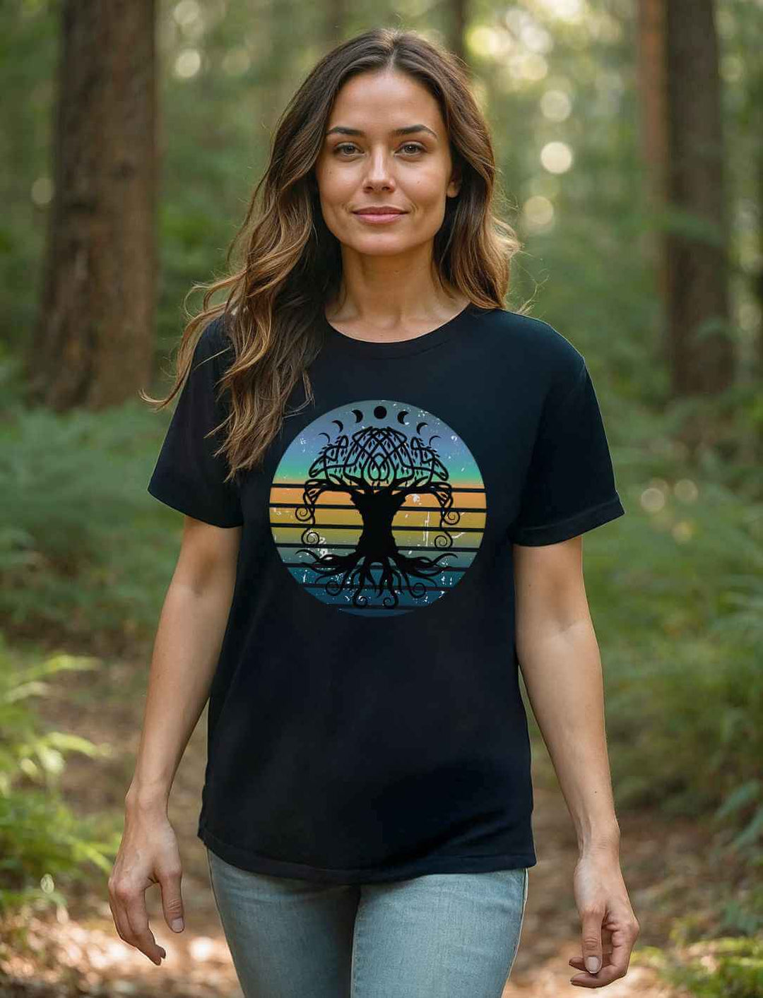 Frau im schwarzen Oversized-Shirt mit Yggdrasil-Motiv, steht im lichten Wald – Symbol für Harmonie, Naturverbundenheit und Stärke.