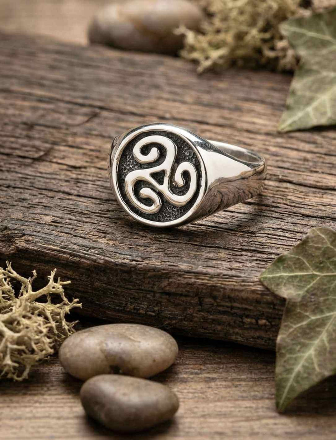 Keltischer Triskele Ring aus 925 Sterling Silber auf Holzuntergrund, inspiriert von Brú na Bóinne