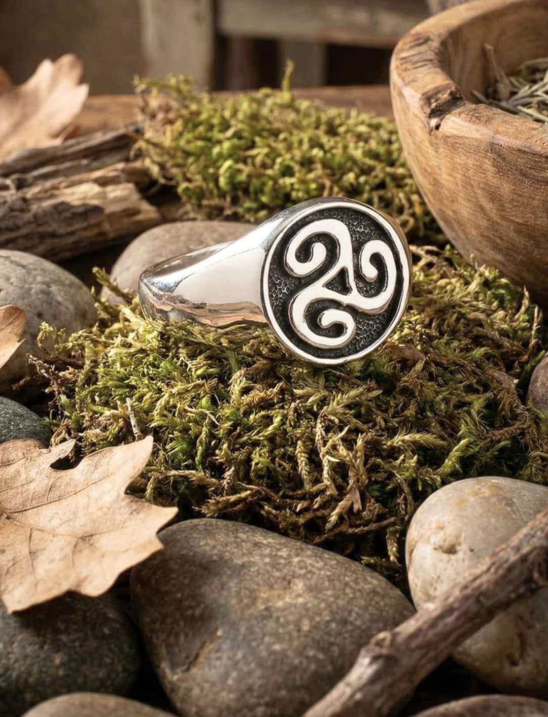 Keltischer Triskele Ring aus Silber in natürlichem Setting mit Moos und Steinen