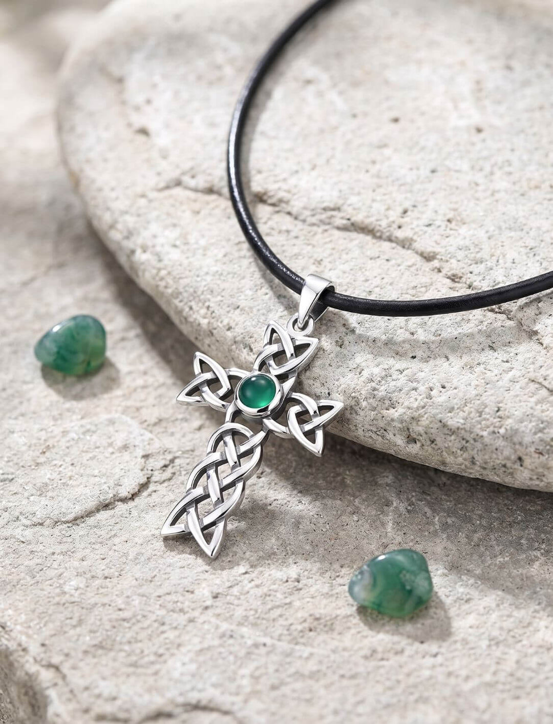 Achat Anhänger aus Silber mit keltischem Knotenkreuz am Lederband auf einem Flussstein
