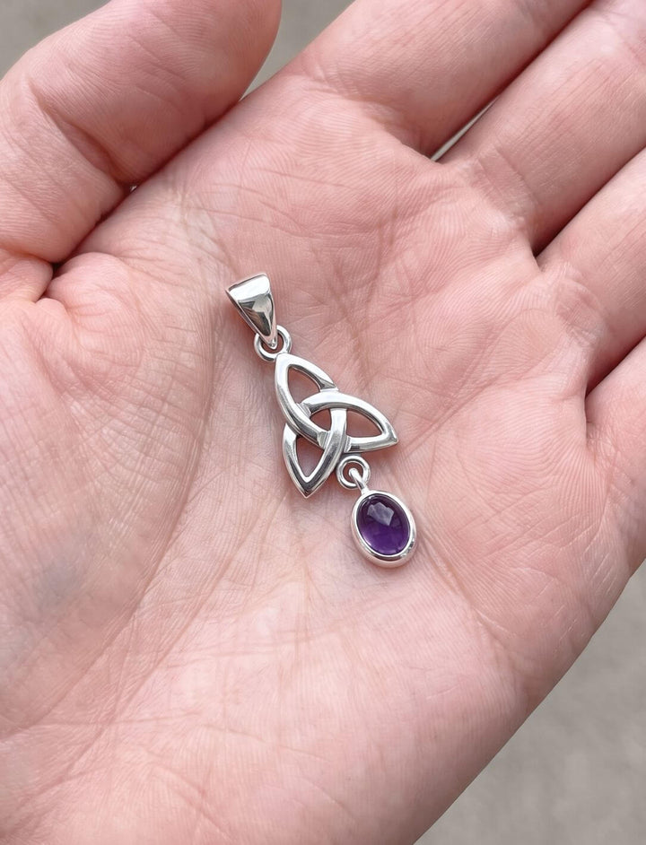 Größenvergleich: der kleine Triquetra Anhänger mit Amethyst liegt in einer geöffneten Handfläche