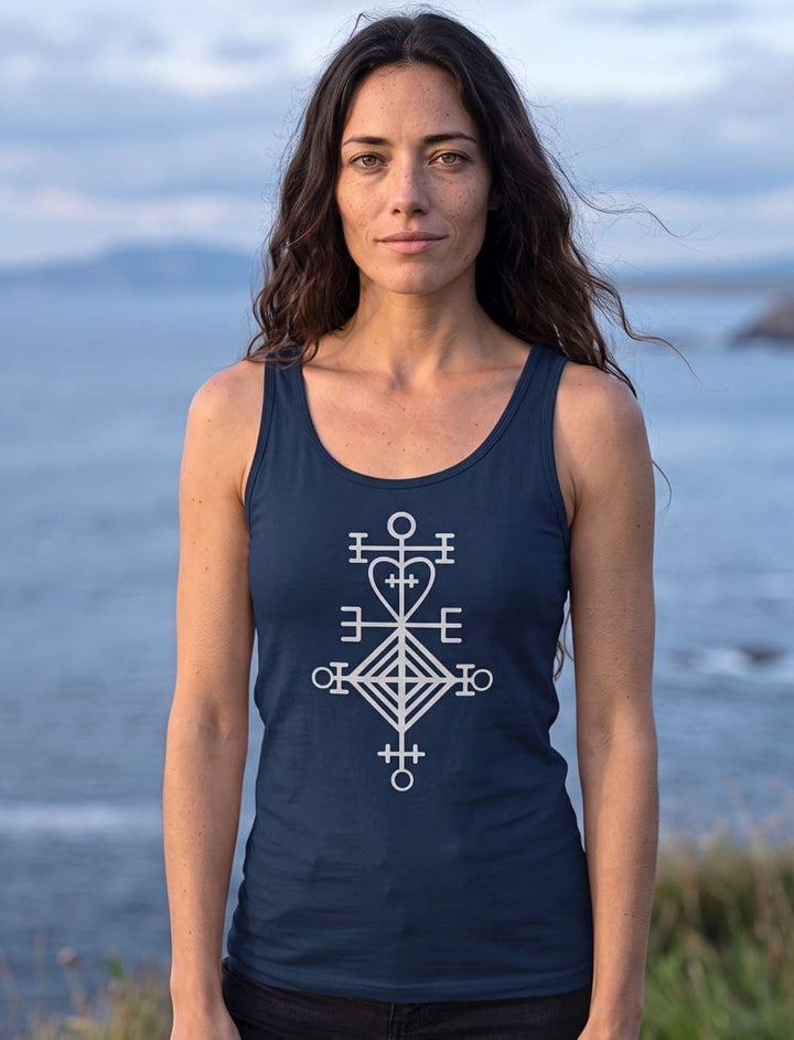 Frau im dunkelblauen Damen Tank Top mit hellem Astarstafur-Symbol, Küstenlandschaft im Hintergrund
