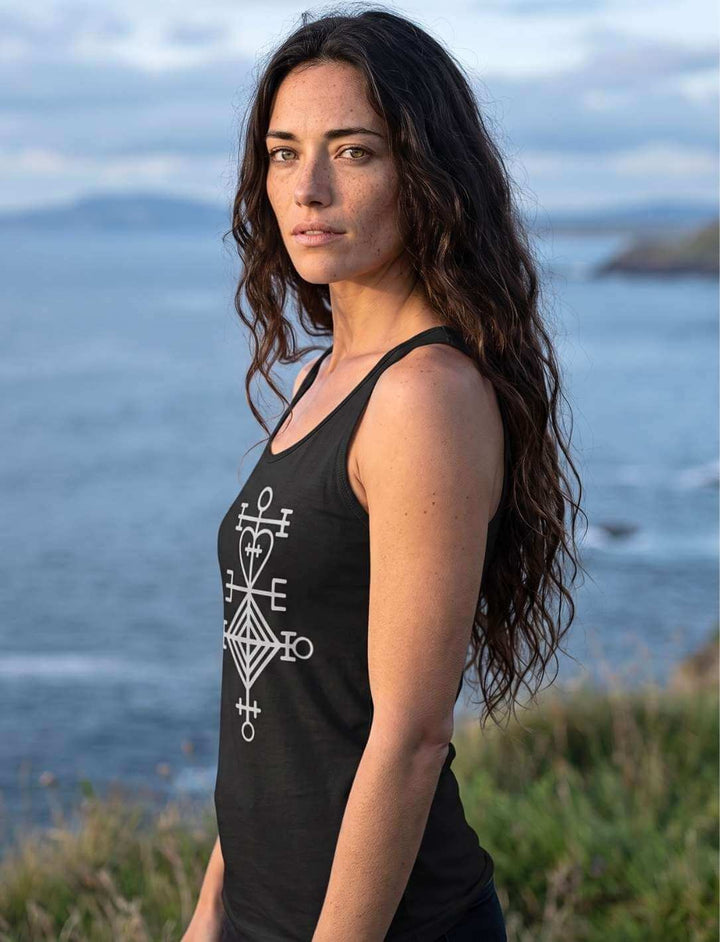 Seitenansicht des schwarzen Damen Tank Tops mit hellem Runensymbol vor Meer und Wolken
