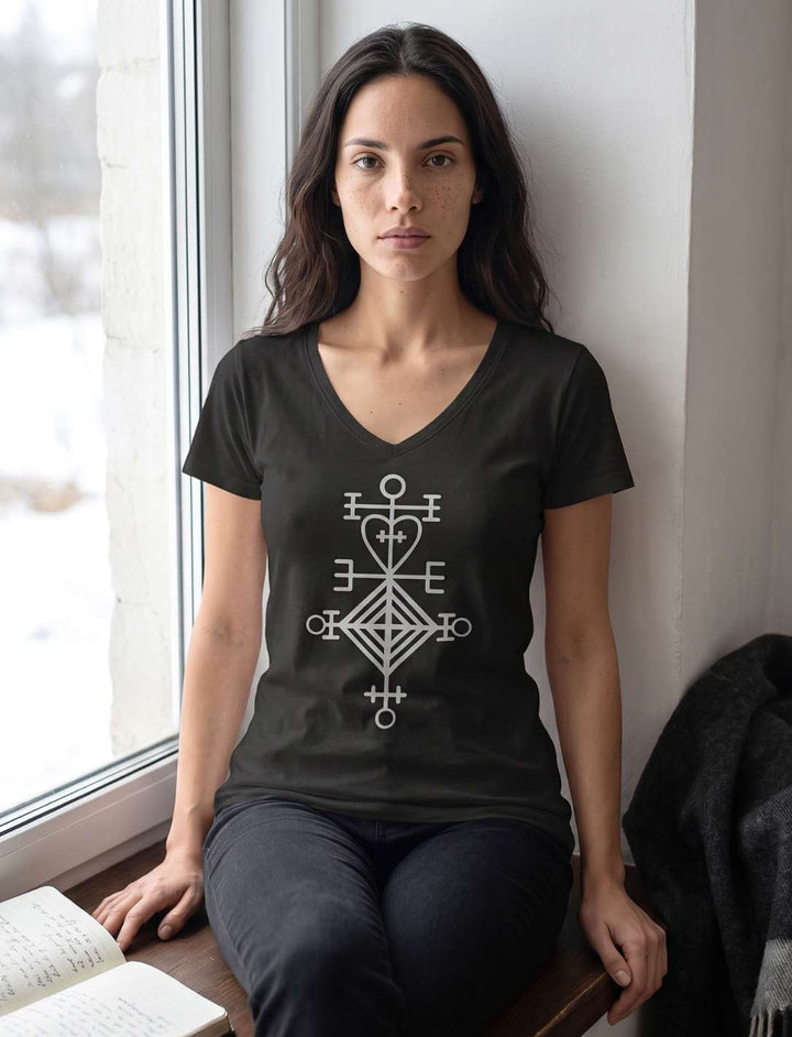 Frau in schwarzem V-Neck Shirt am Fenster vor verschneiter Winterlandschaft