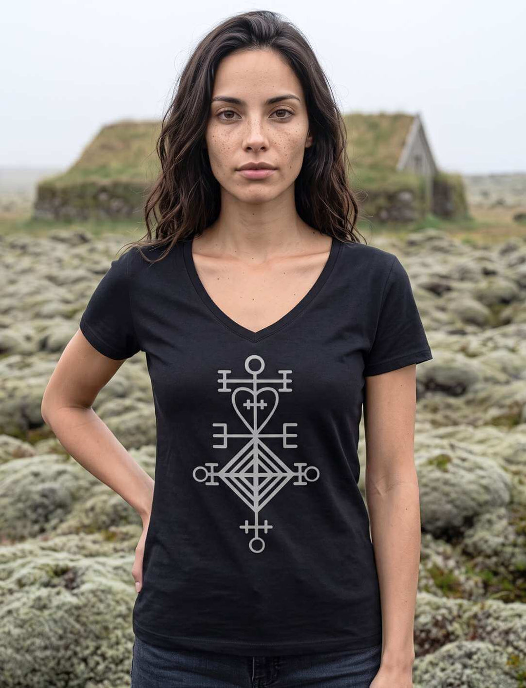 Schwarzes V-Neck Shirt vor moosbewachsenem Lavafeld mit Torfhaus im Hintergrund