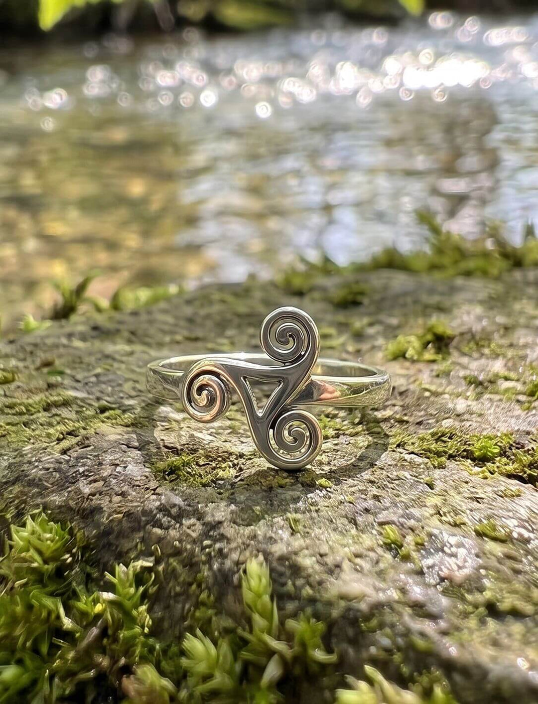 Boanns Quelle: Triskele Ring aus 925 Silber auf moosigem Stein an einer glitzernden Waldquelle unter Haselblättern