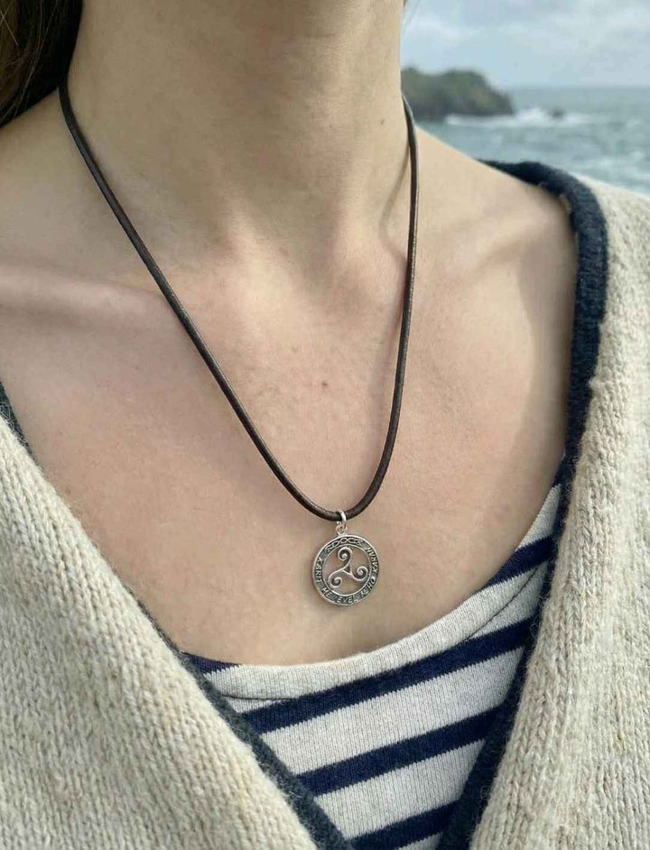 Model trägt bretonischen Triskele Anhänger am Meer.