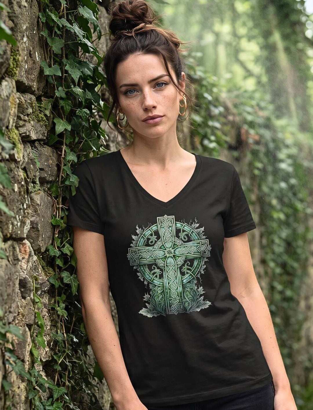 Frau steht im schwarzen Keltenkreuz Shirt vor einer efeubewachsenen Steinwand