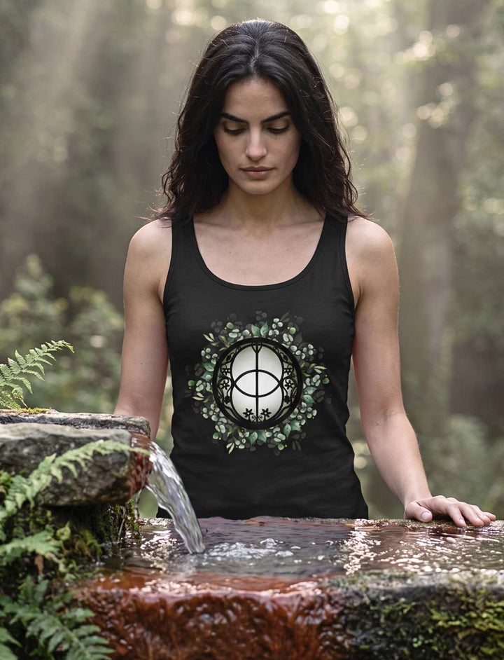 Frau im Chalice Well Damen Tank Top in Schwarz an einer Quelle im Wald