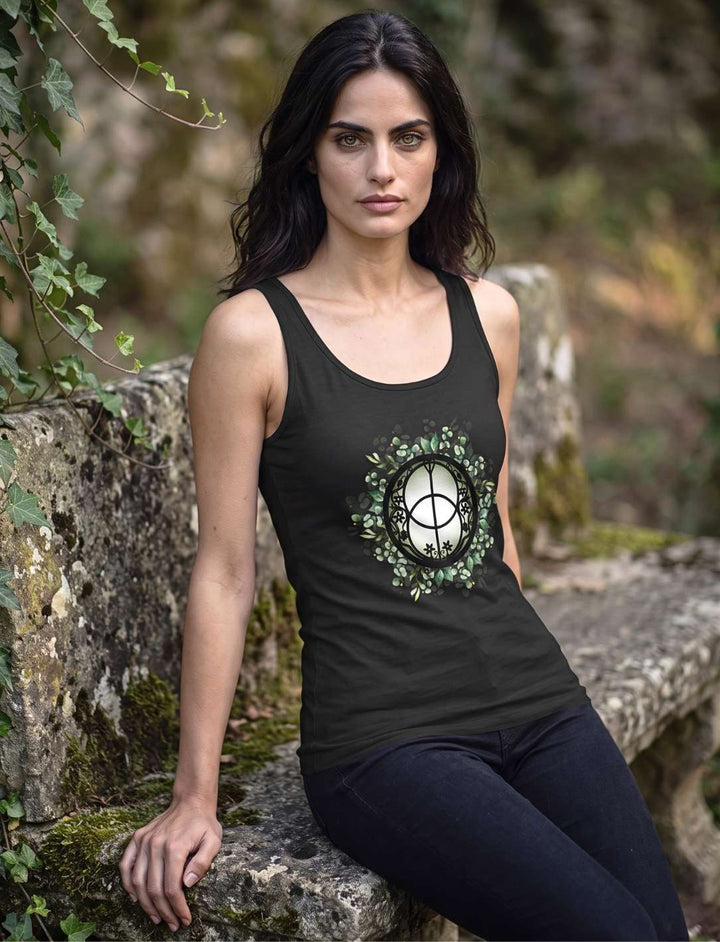 Frau sitzt auf einer Steinmauer im schwarzen Damen Tank Top mit Chalice Well Motiv
