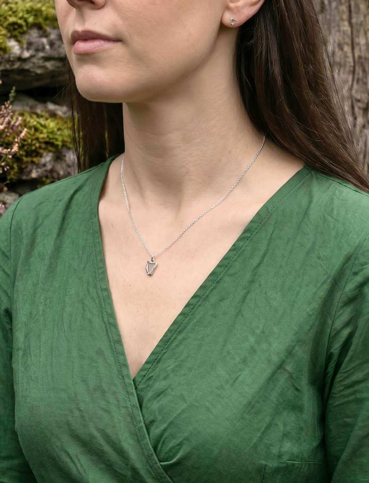 Frau trägt keltische Harfe Silberkette und Ohrstecker – grünes Kleid, Detailaufnahme