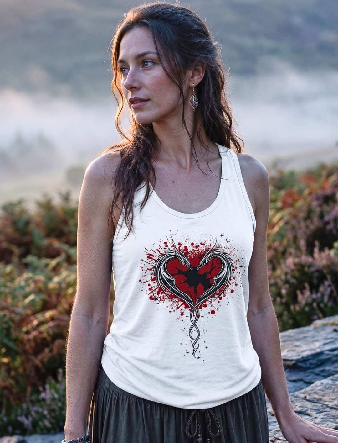 Frau im weißen Tank Top mit Drachenmotiv vor Heidelandschaft, rotes Herz und helle Drachen deutlich sichtbar