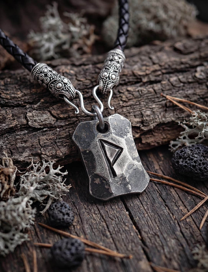 Wunjo Rune Anhänger an geflochtener Lederkette mit versilberten Rabenköpfen auf Rinde mit Flechten und Lavasteinen