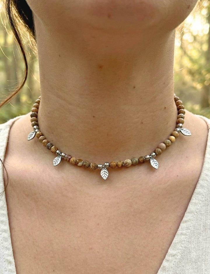 Frau trägt handgefertigten Holzperlen Choker mit Edelstahl-Blättern im Wald