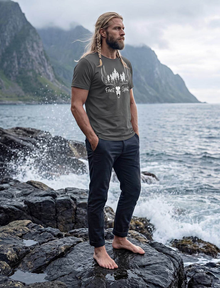 Mann im anthrazitfarbenen Wald T-Shirt steht barfuß auf Felsen an einer nordischen Fjordküste