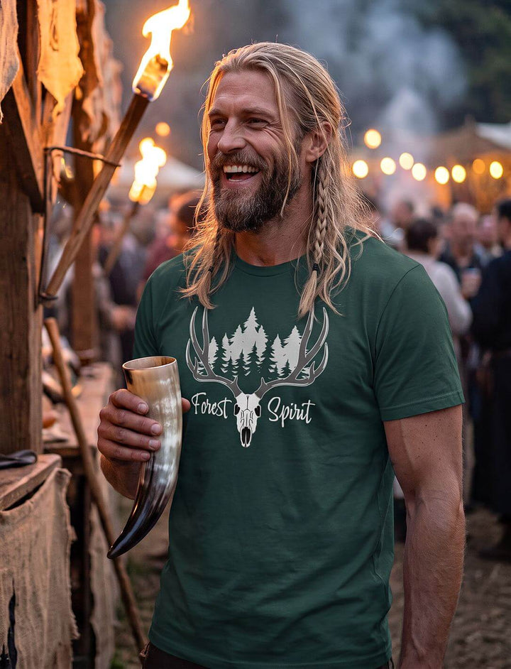 Lachender Mann im grünen Forest Spirit Shirt mit Trinkhorn auf einem abendlichen Mittelaltermarkt mit Fackeln