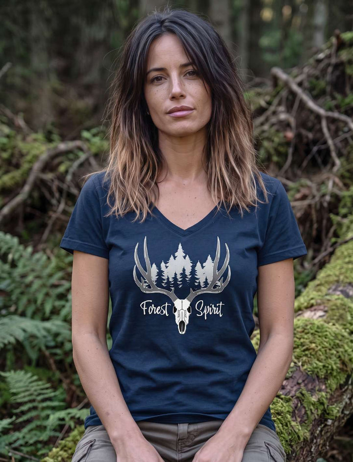 Frau im navyblauen Damenshirt mit Waldmotiv, sitzend vor bemoostem Holz