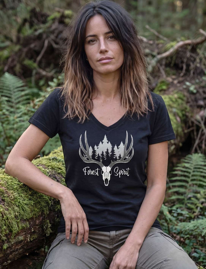 Schwarzes Damenshirt mit Geweih und Tannen, Frau sitzend zwischen Moos und Unterholz