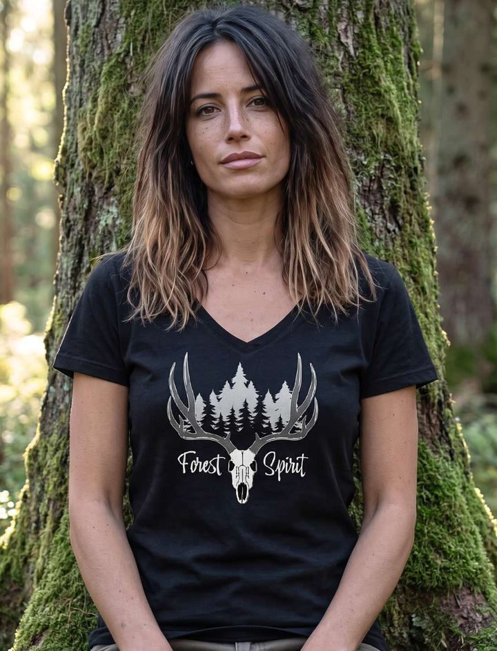 Frau im schwarzen V-Neck Shirt mit Hirschmotiv, sitzend auf einem gestuerzten Baumstamm im Farn