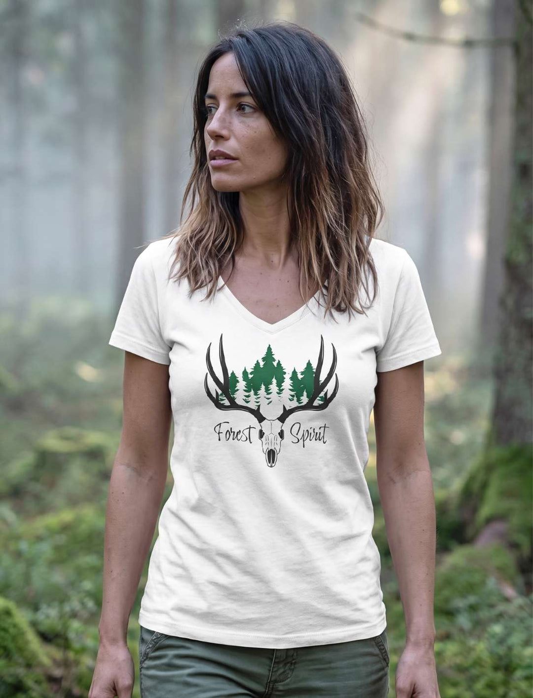 Weisses Damenshirt mit tiefgruenen Tannen im Geweih, Frau stehend am Waldrand