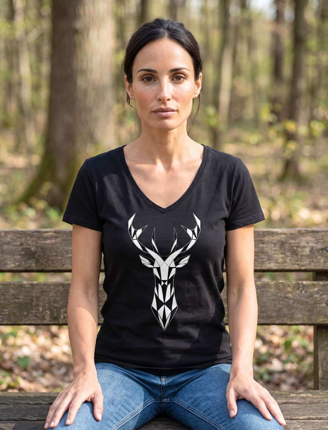 Frau sitzt auf einer Waldbank im schwarzen Damen V-Neck Shirt mit Hirschmotiv