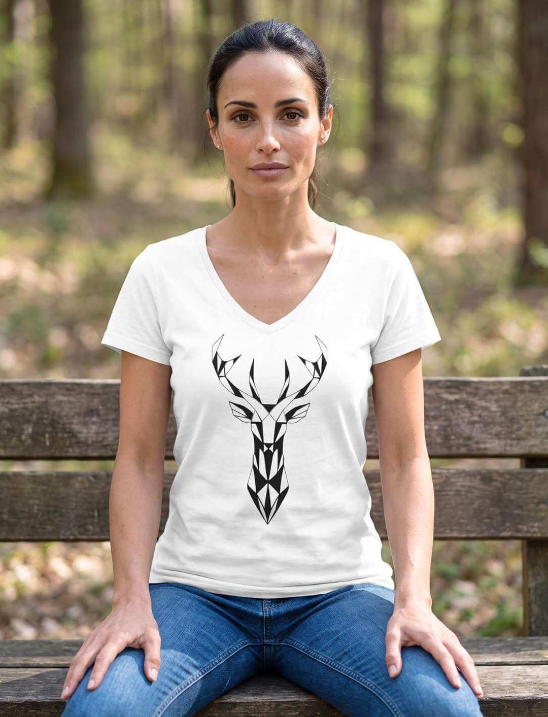 Weißes Damen V-Neck Shirt mit Hirschmotiv auf einer Holzbank im Wald
