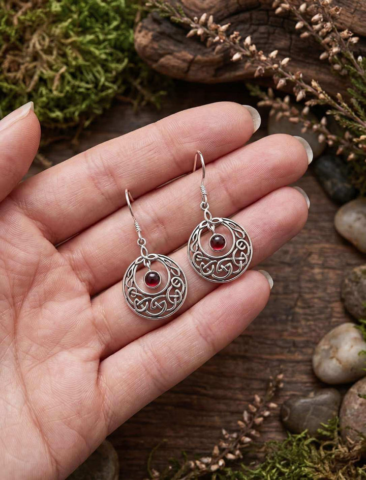 Granatkreis des keltischen Knotens Silber Ohrhänger in der Hand als Größenvergleich