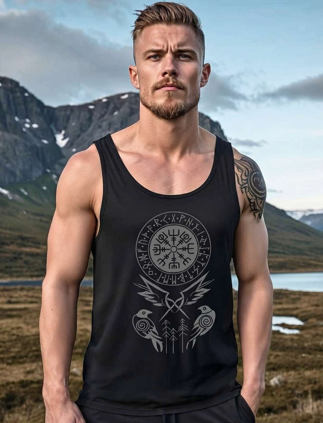 Mann trägt schwarzes Wikinger Tanktop mit Vegvisir und Odin Raben Motiv vor Fjordlandschaft