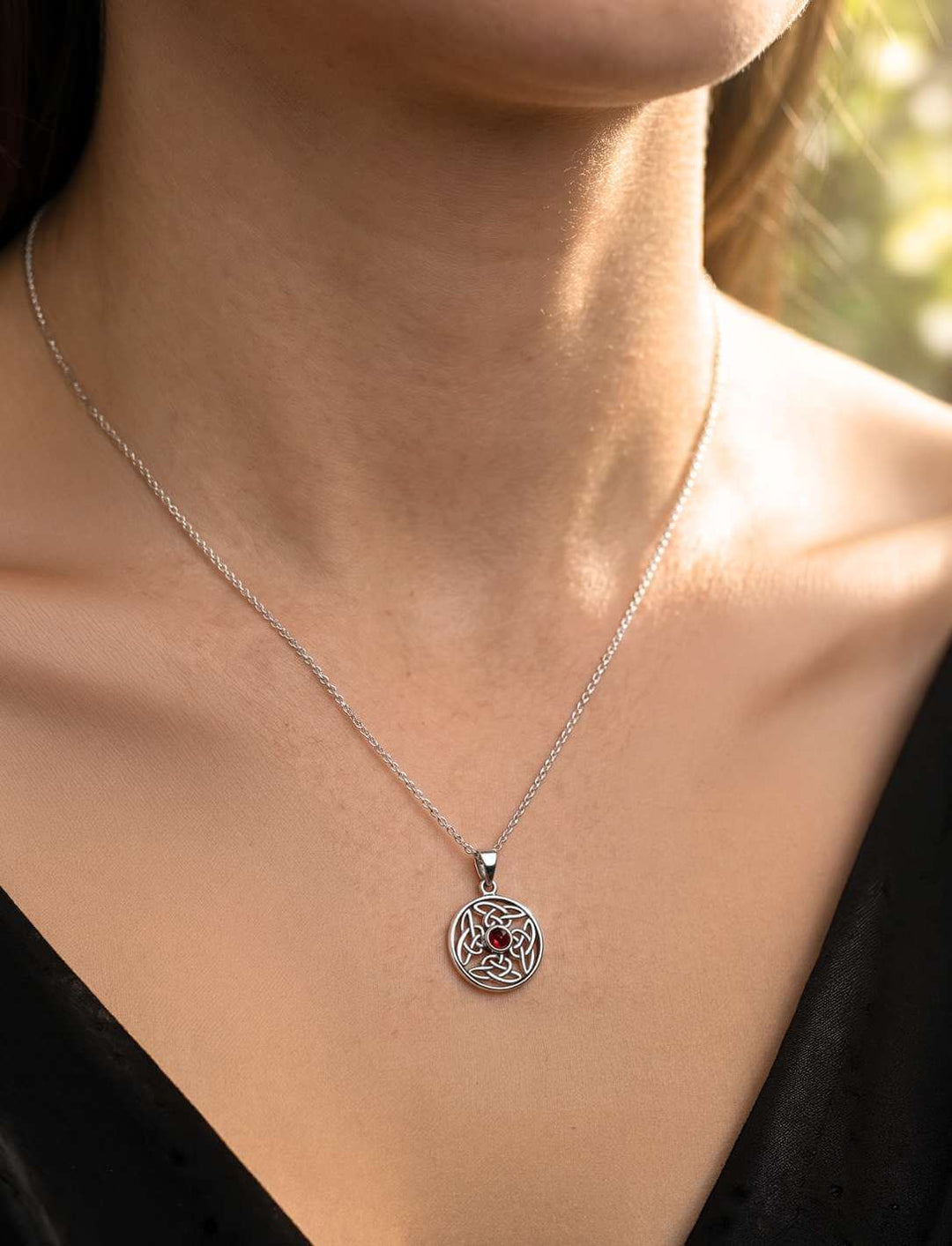 Silber Anhänger mit Granat an schwarzer Lederkordel am Hals getragen
