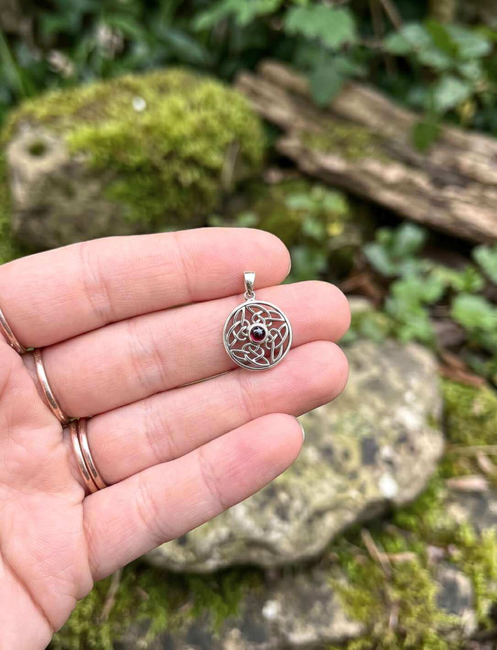 Keltischer Silber Anhänger mit Granat in einer Hand gehalten