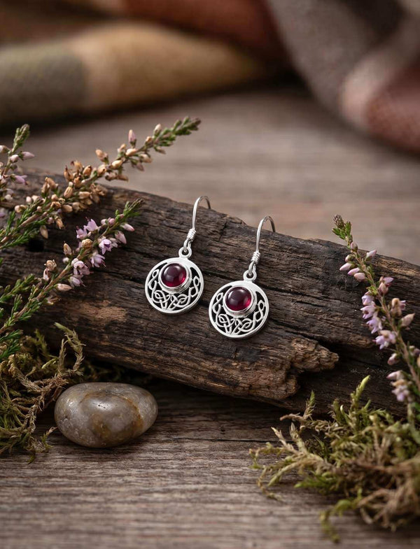 Kleine keltische Ohrringe aus Silber mit echtem Granat auf Holz und Moos