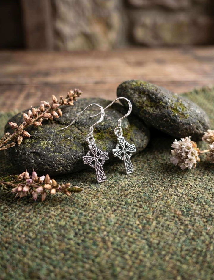 Keltenkreuz Silber Ohrhänger auf moosbedecktem Stein mit Heidekraut und Wollstoff