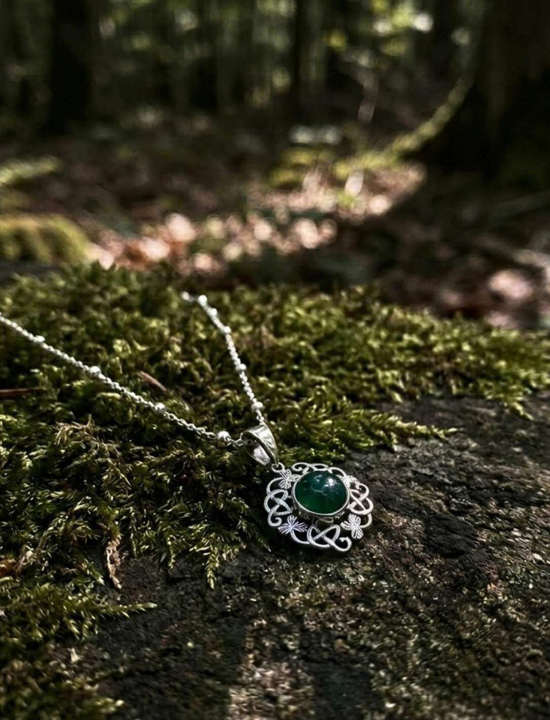 Keltischer Kleeblatt-Anhänger in 925 Silber an Silberkette auf Moos liegend