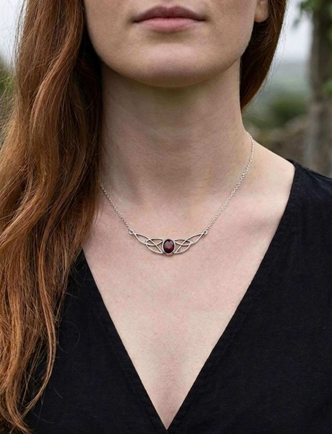 Frau trägt keltische Knotenkette mit Granat in 925 Silber
