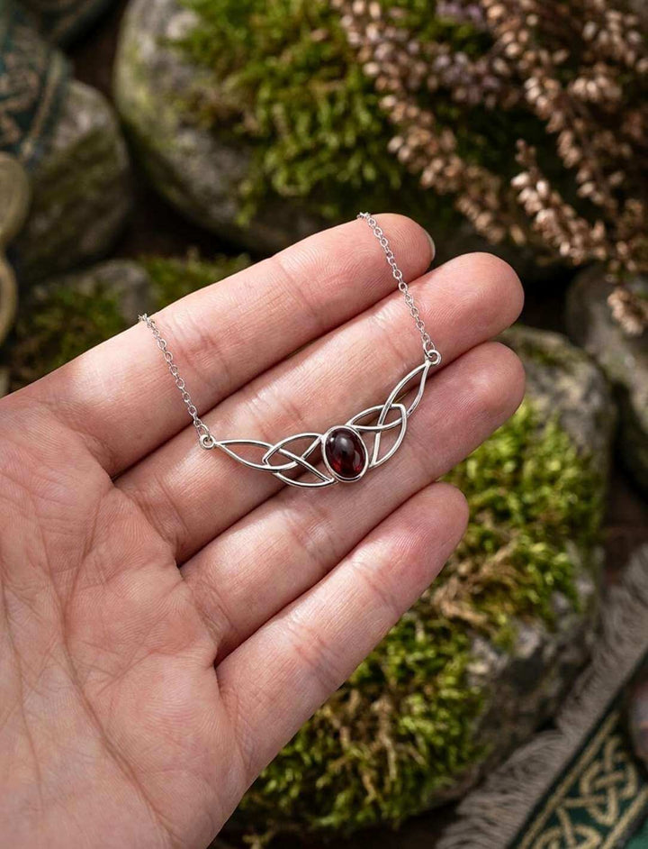Keltische Silberkette mit Granat-Cabochon in einer Hand